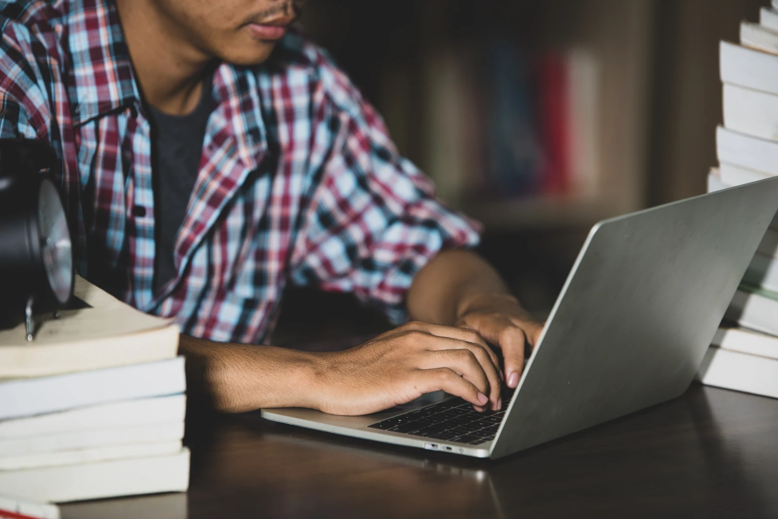 Student typing on a laptop at a desk while working on a Cal State Apply application