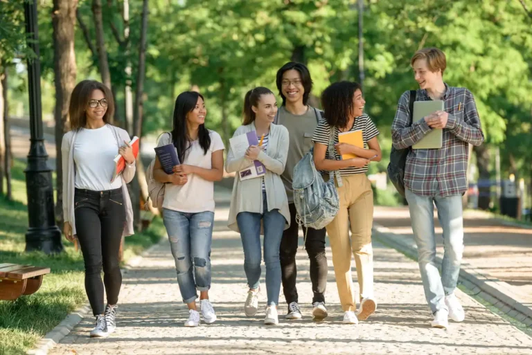 Group of college students walking together along a sunny campus path