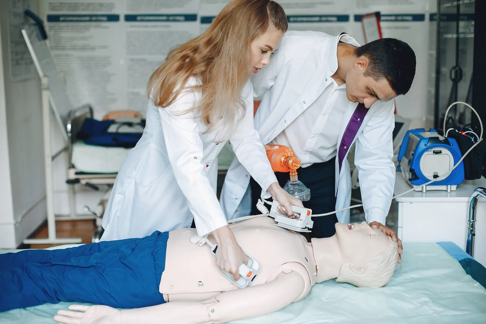 Nursing students practicing CPR on a training mannequin in a simulation lab