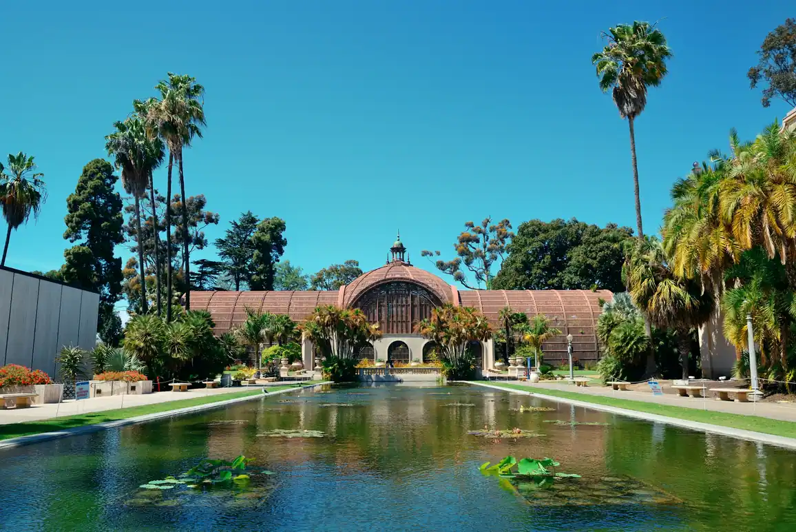 Spanish Revival architecture and palm trees reflected in a pond in San Diego