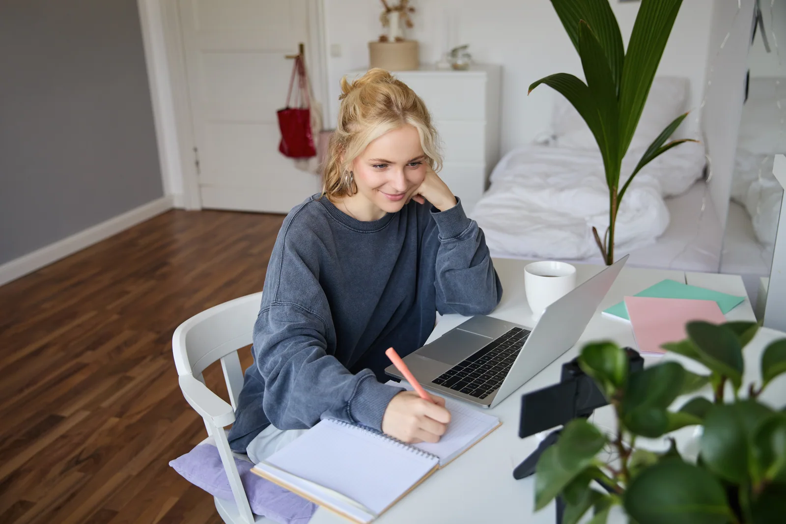Student taking notes at a laptop at home while completing a Cal State Apply application for Fall 2027