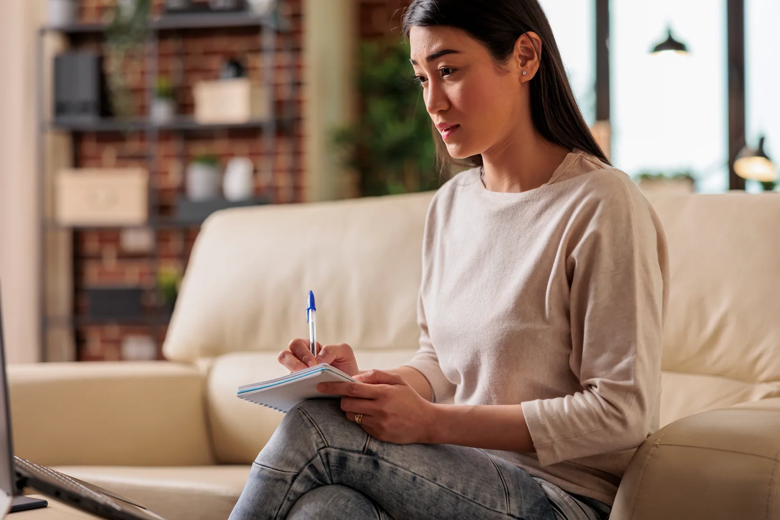 Student taking notes at home while working on a Cal State Apply application