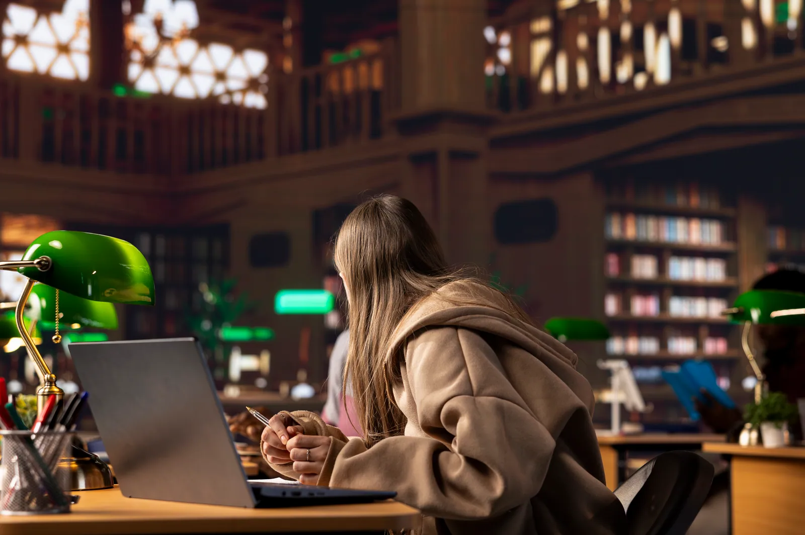 Student working on a laptop in a campus library reading room